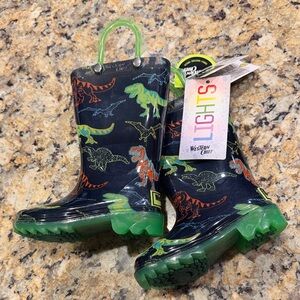 Western Chief Kids Light-Up Dinosaur Rain Boots with Green Handles.